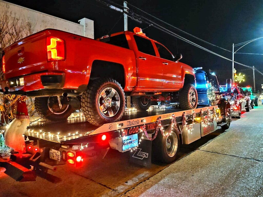 flatbed towing service in Palestine TX transporting pickup truck at night